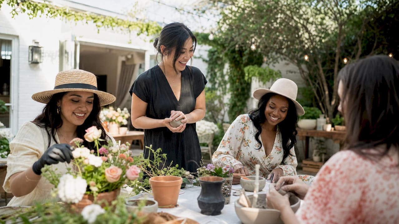 Hands creating flower crowns and painting