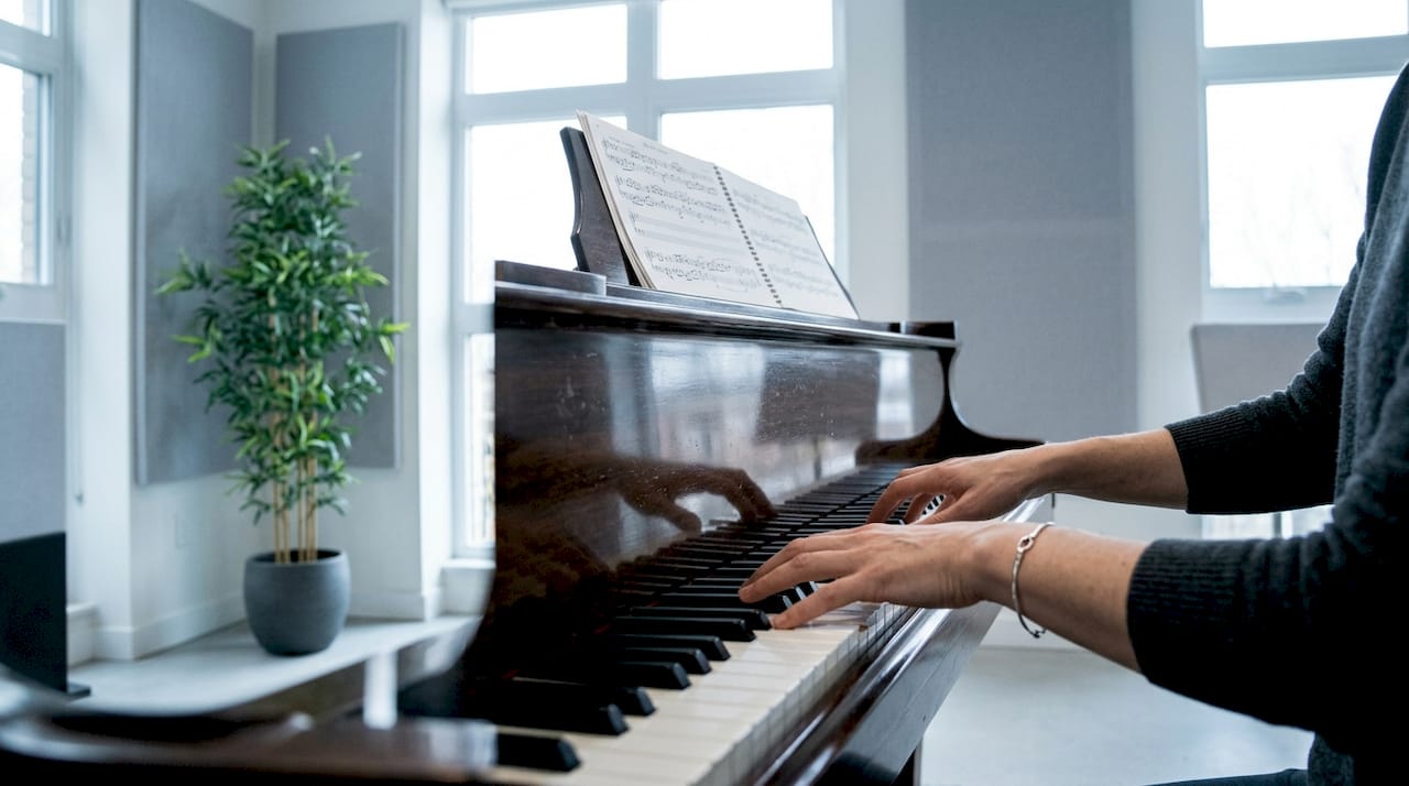 Pianist hands adjusting sheet music on grand piano