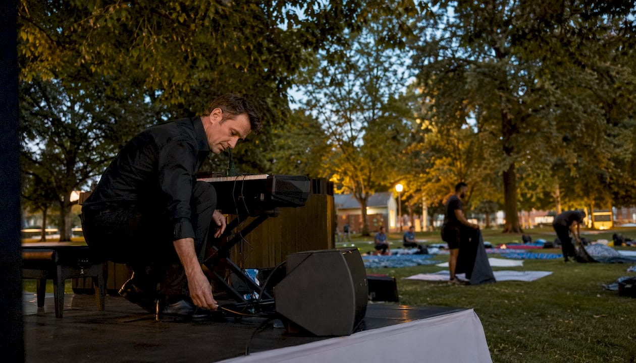 Pianist preparing keyboard at outdoor event