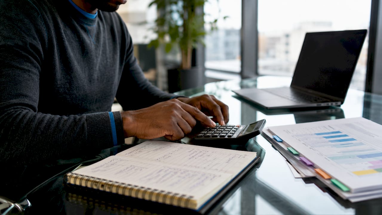 Hands calculating unit economics with reports
