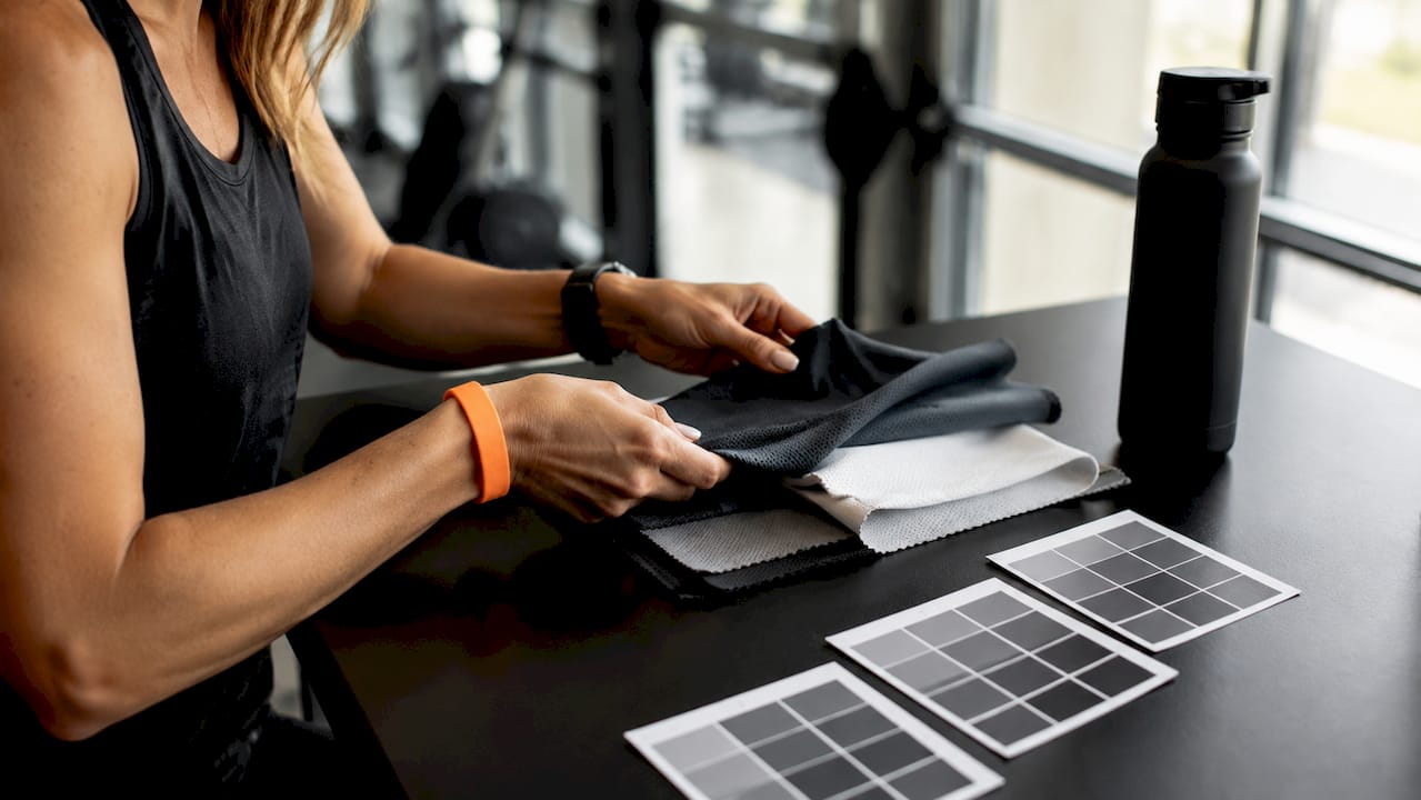 Hands examining youth hockey fabric swatches