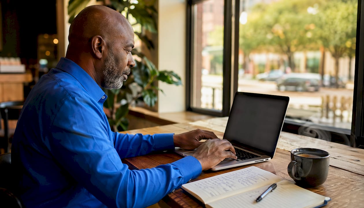 Hands typing on laptop updating Google Business Profile