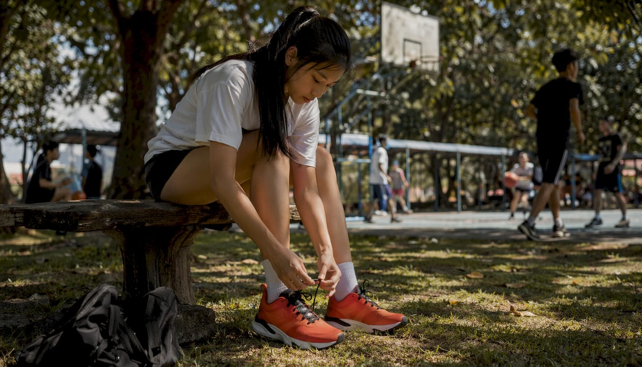 Teen athlete fitting proper sports footwear