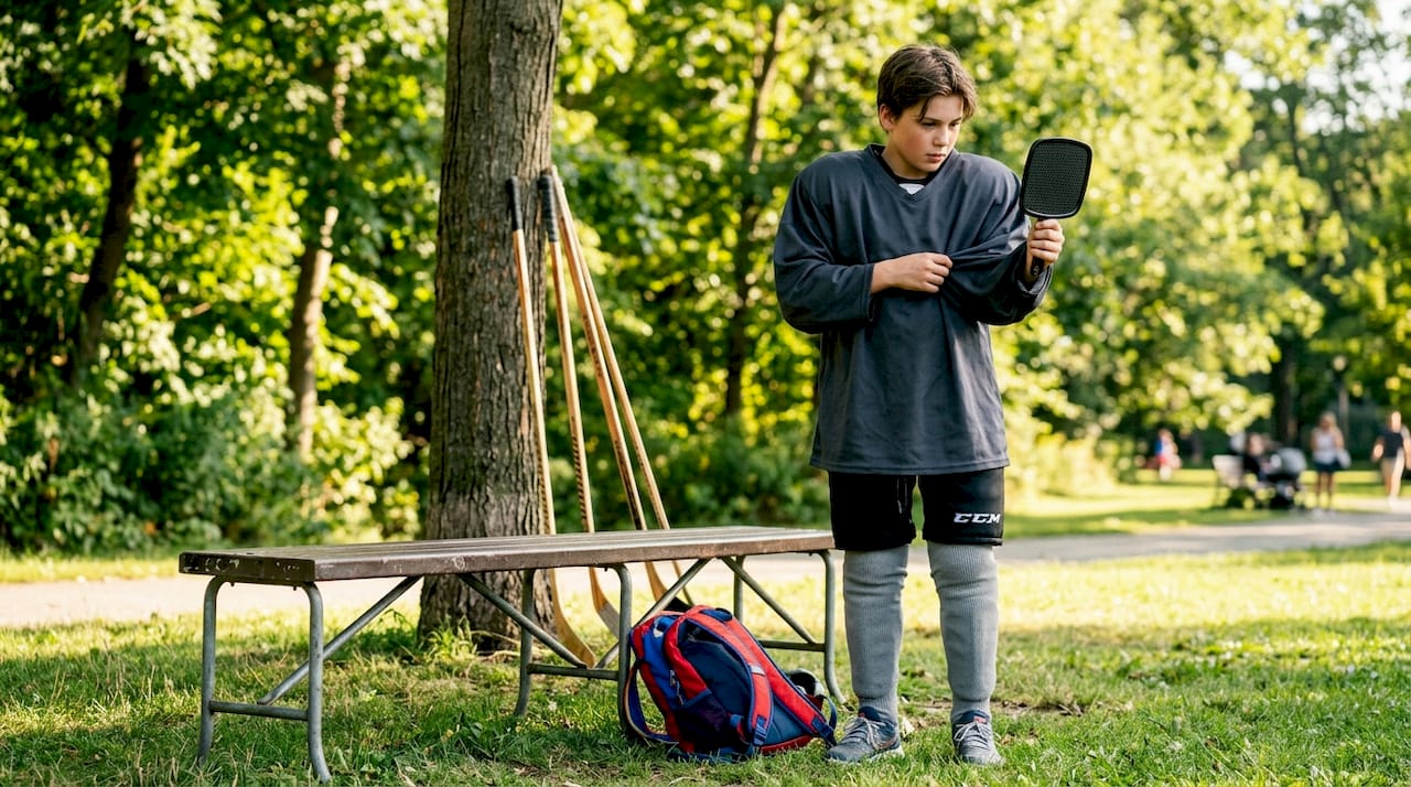 Youth player assessing reversible jersey fit over pads