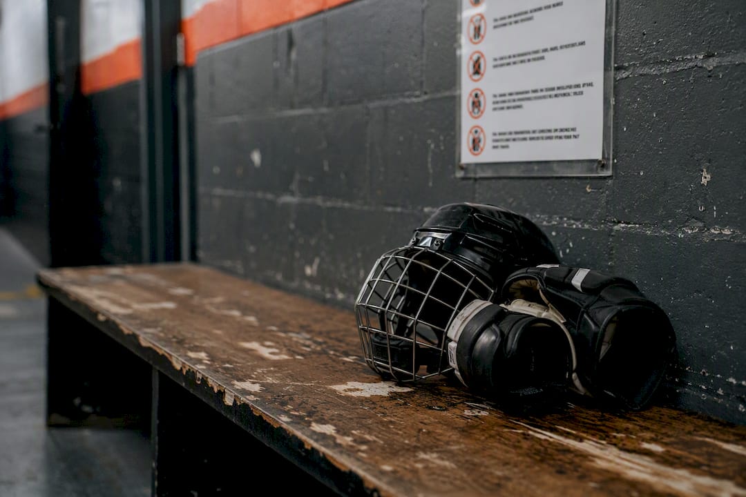 Locker room bench with hockey gear and rules poster