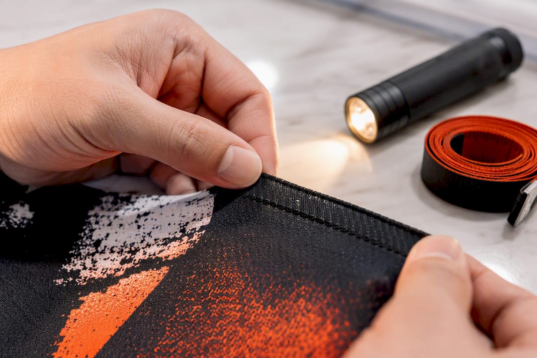 Hands inspecting garment seam and print