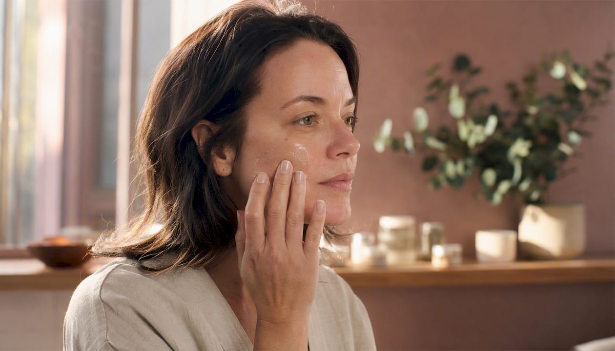 Woman applying serum to face naturally