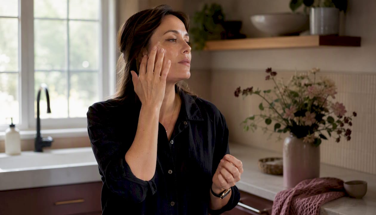Woman applying facial serum at home