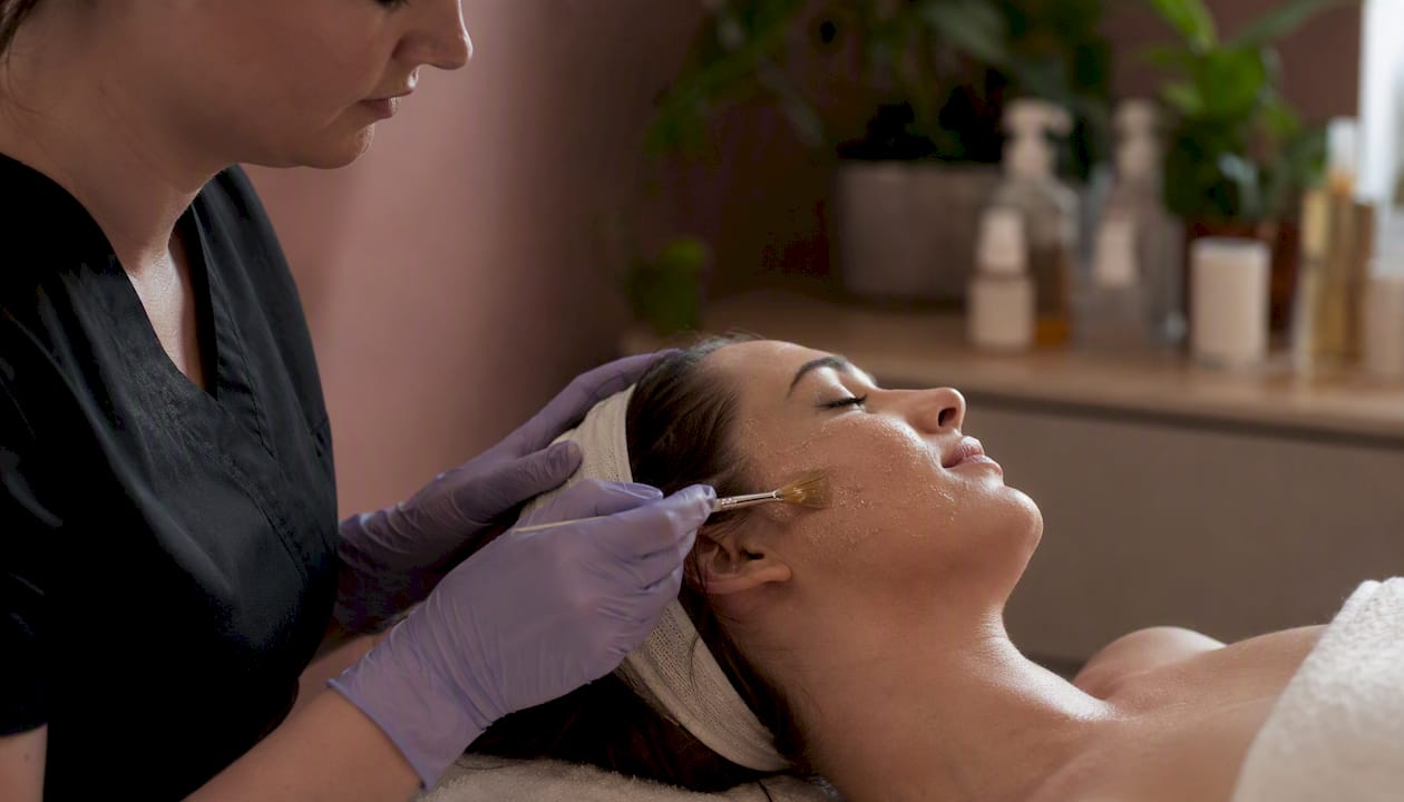 Clinician applying chemical peel to facial skin