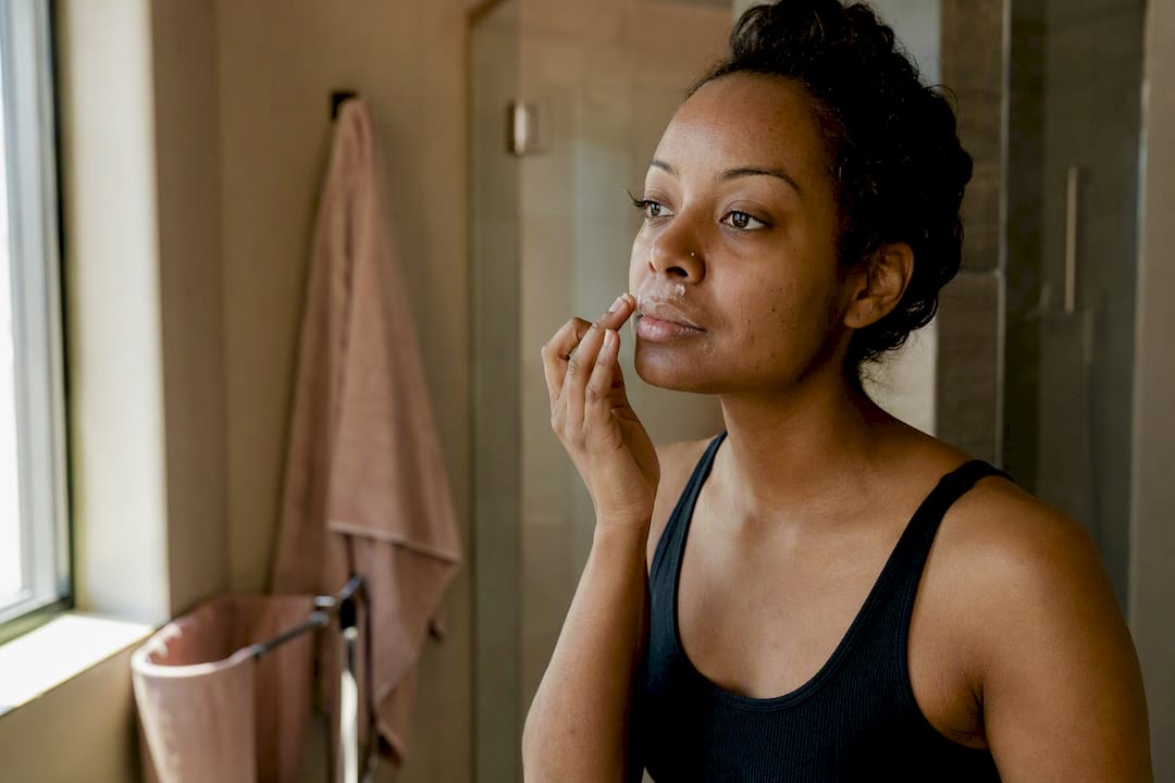Applying soothing balm post hair removal on dark skin
