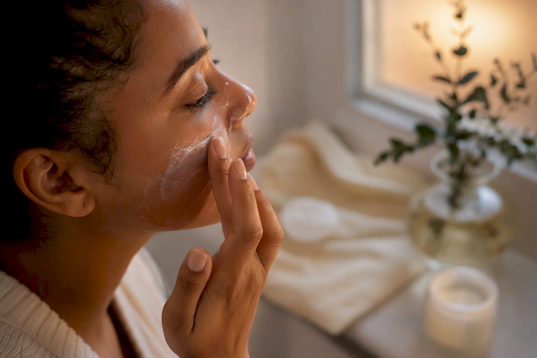 Woman applying sunscreen on pigmented skin