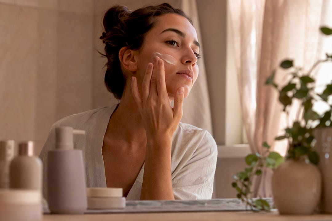 Hand applying retinol alternative cream to cheek