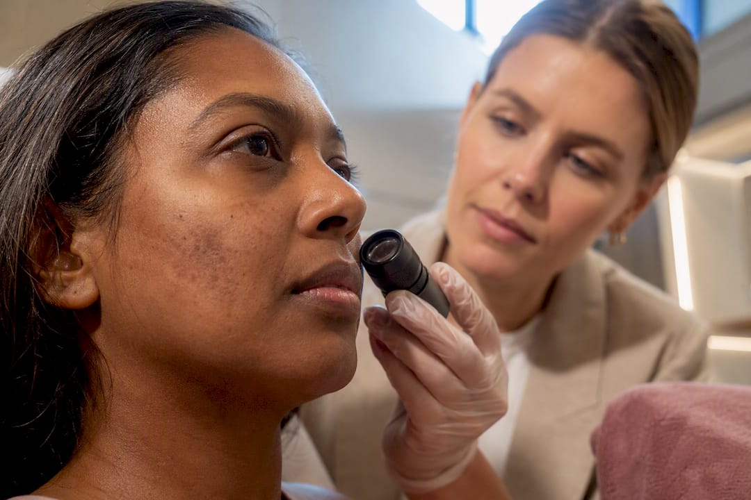 Clinician assessing facial pigmentation in clinic