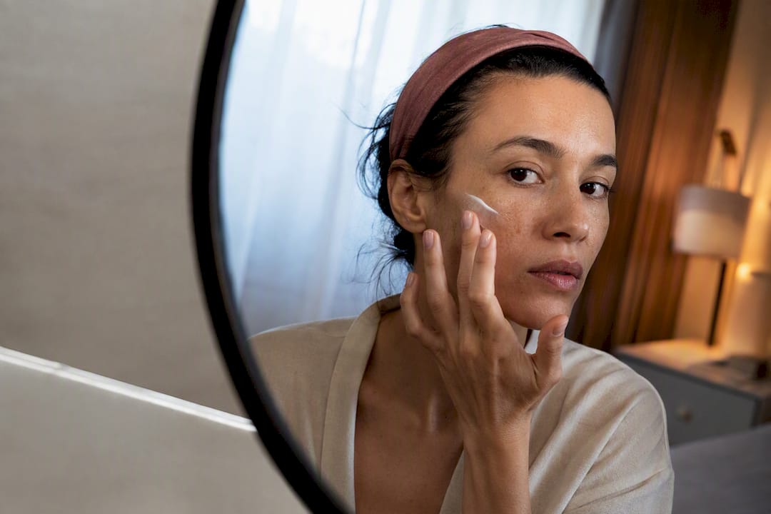 Woman applying topical treatment to cheek