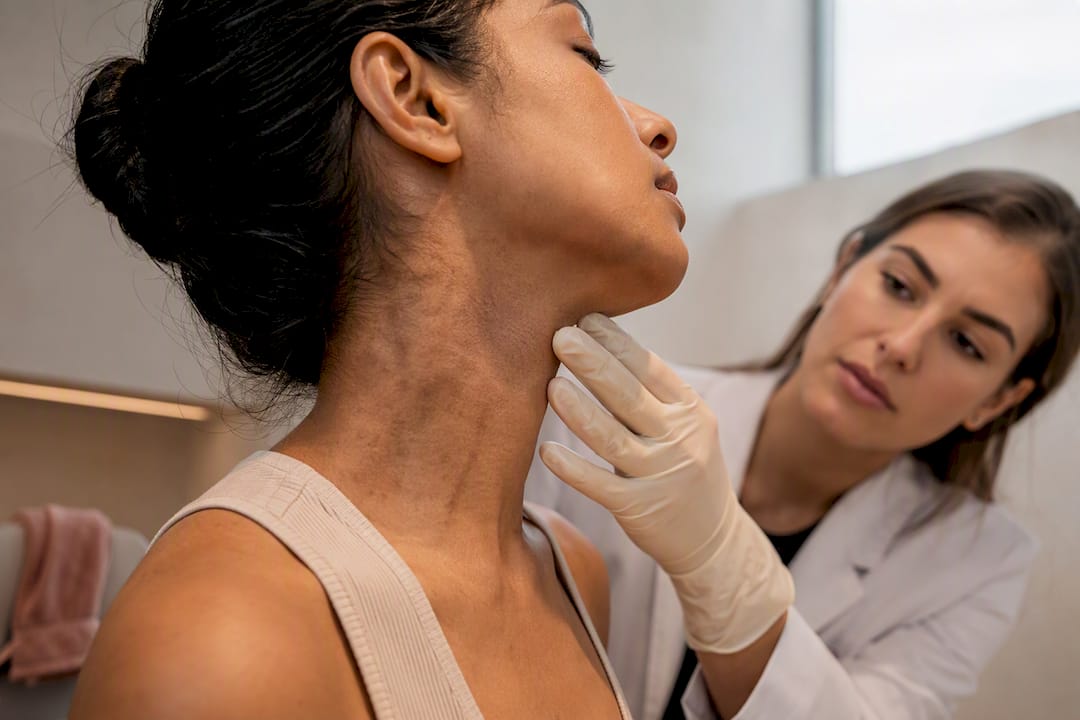 Clinician assessing neck pigmentation in studio