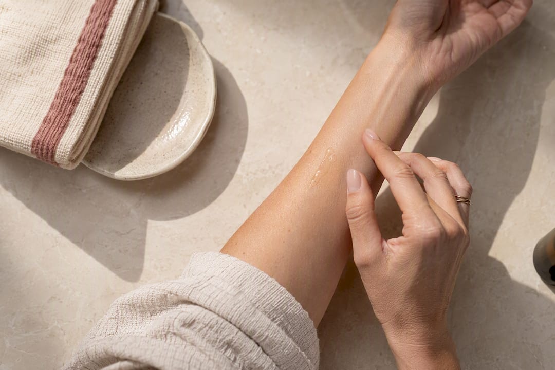 Woman patch testing serum on forearm