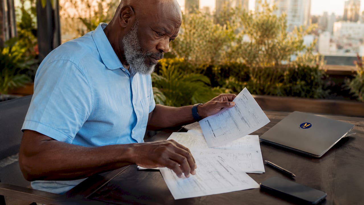Hands typing next to permit documents on desk