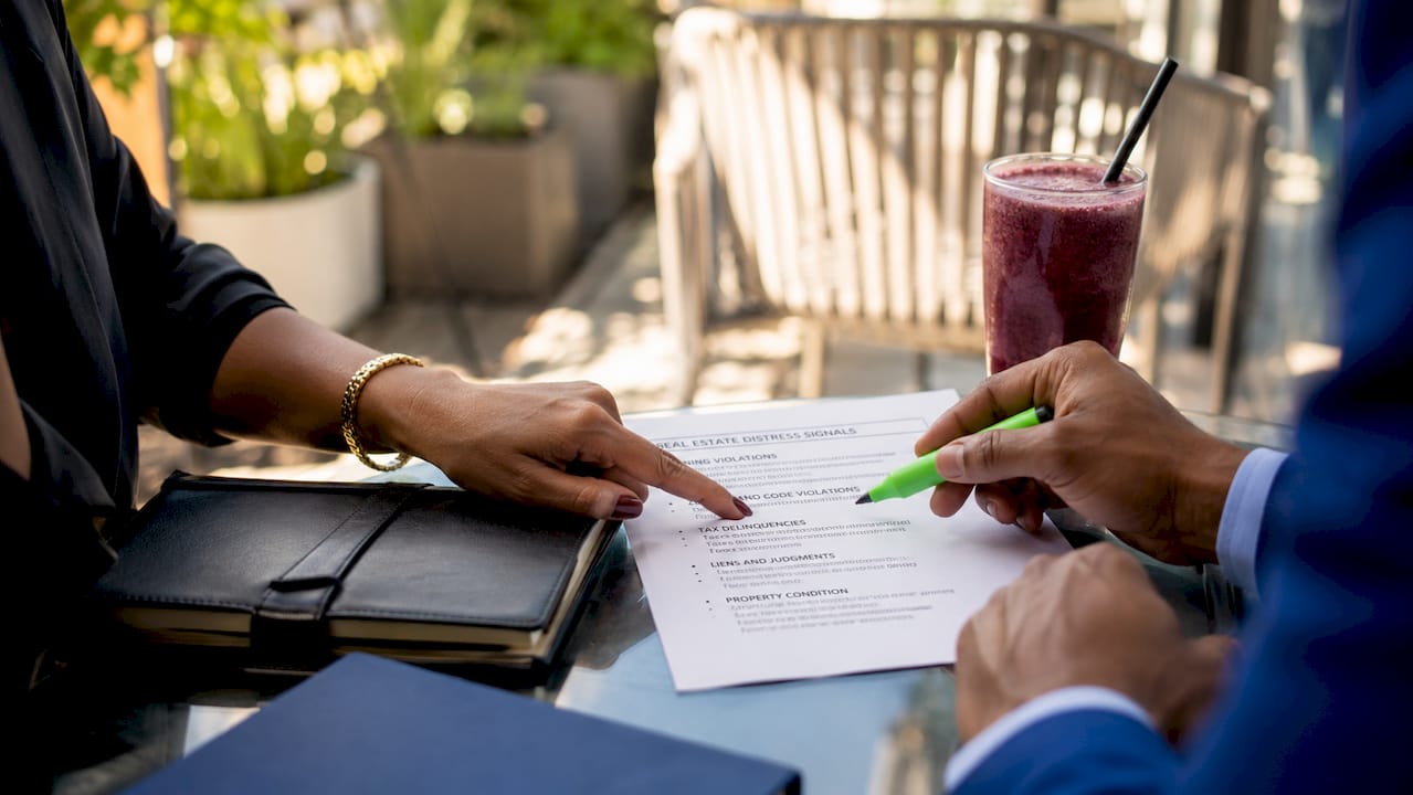 Hands pointing at real estate distress signals list