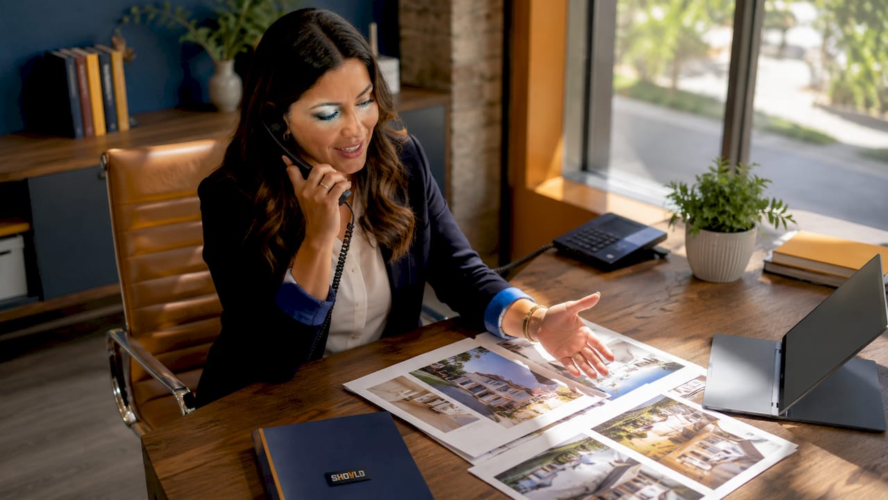 Real estate broker negotiating on phone at desk