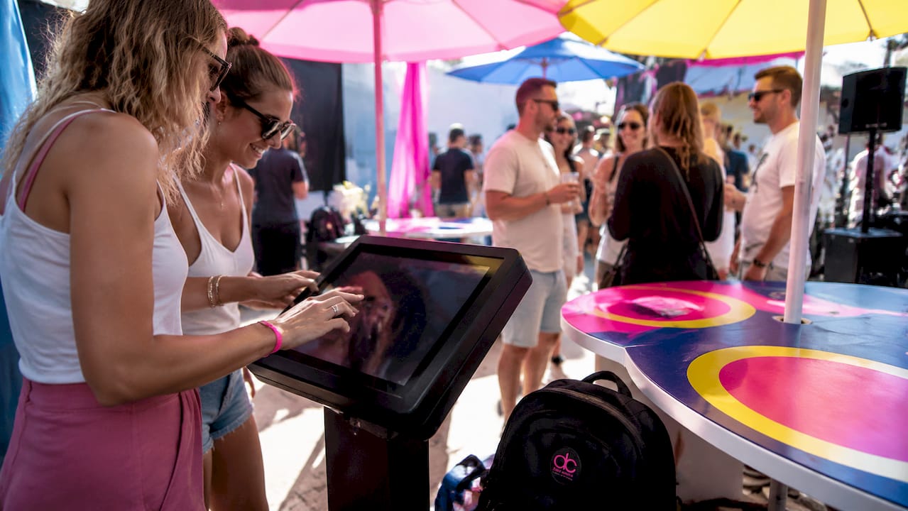 Besucher bedienen das Gamification-Terminal direkt am Messestand mit ihren Händen.