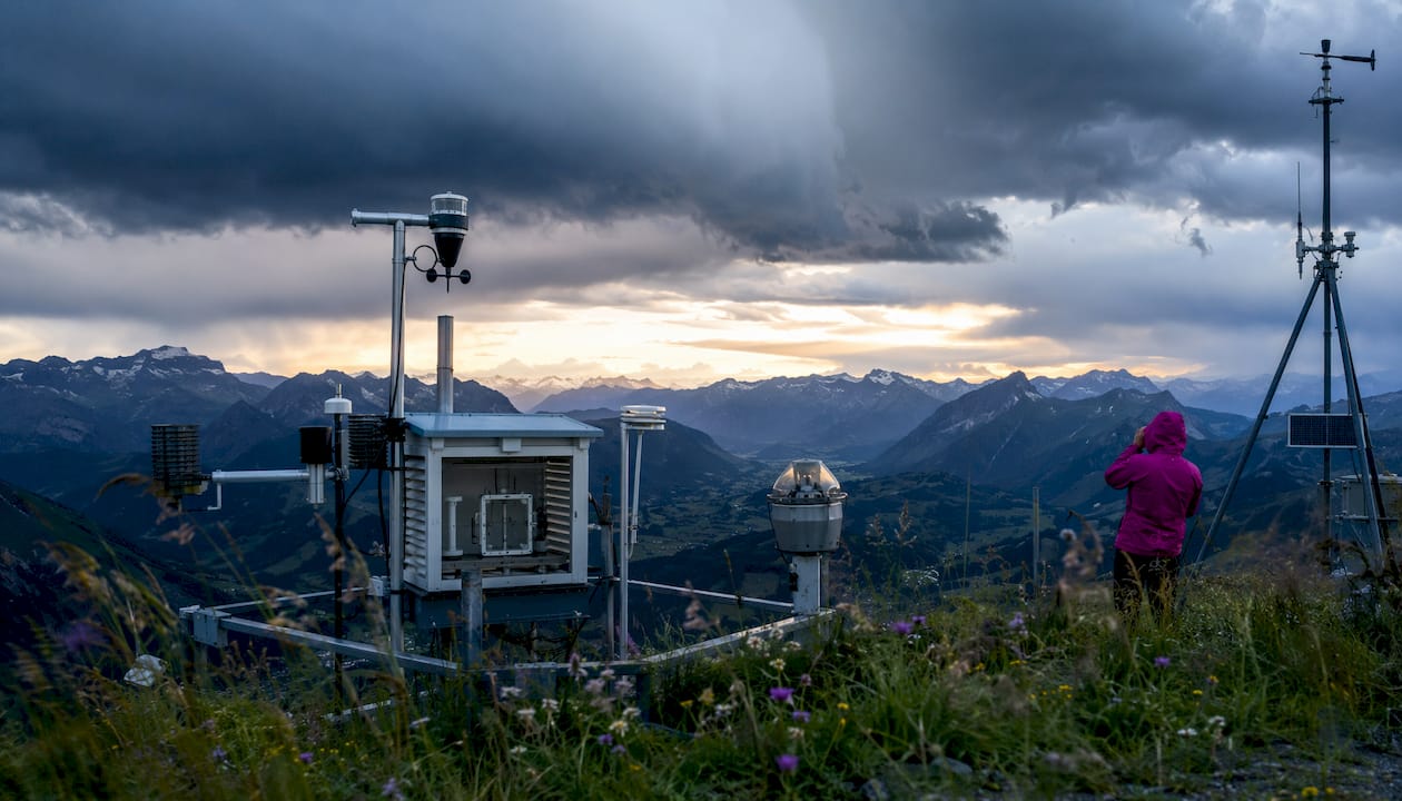 Wetterstation im Alpenraum mit Blick auf dunkle Gewitterwolken