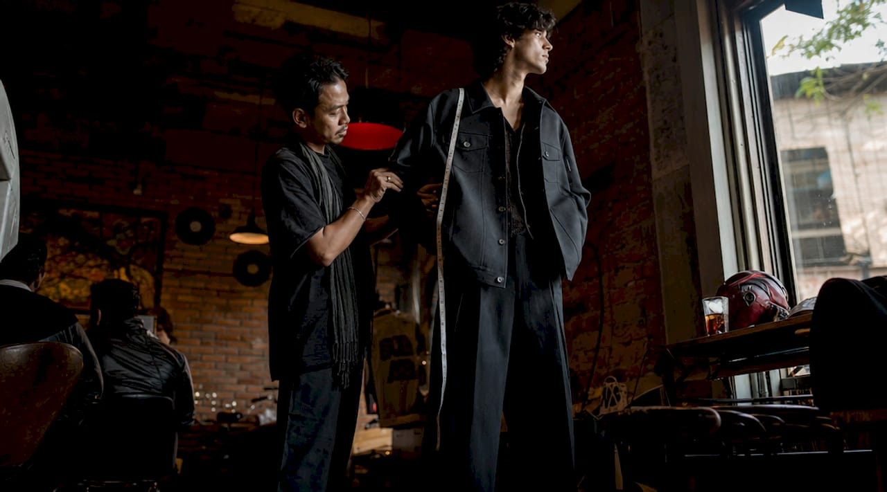 Stylist fitting oversized streetwear on model