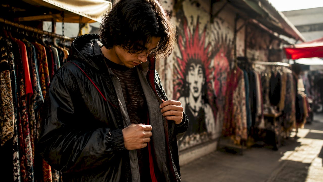 Hand examining layered streetwear fabric textures