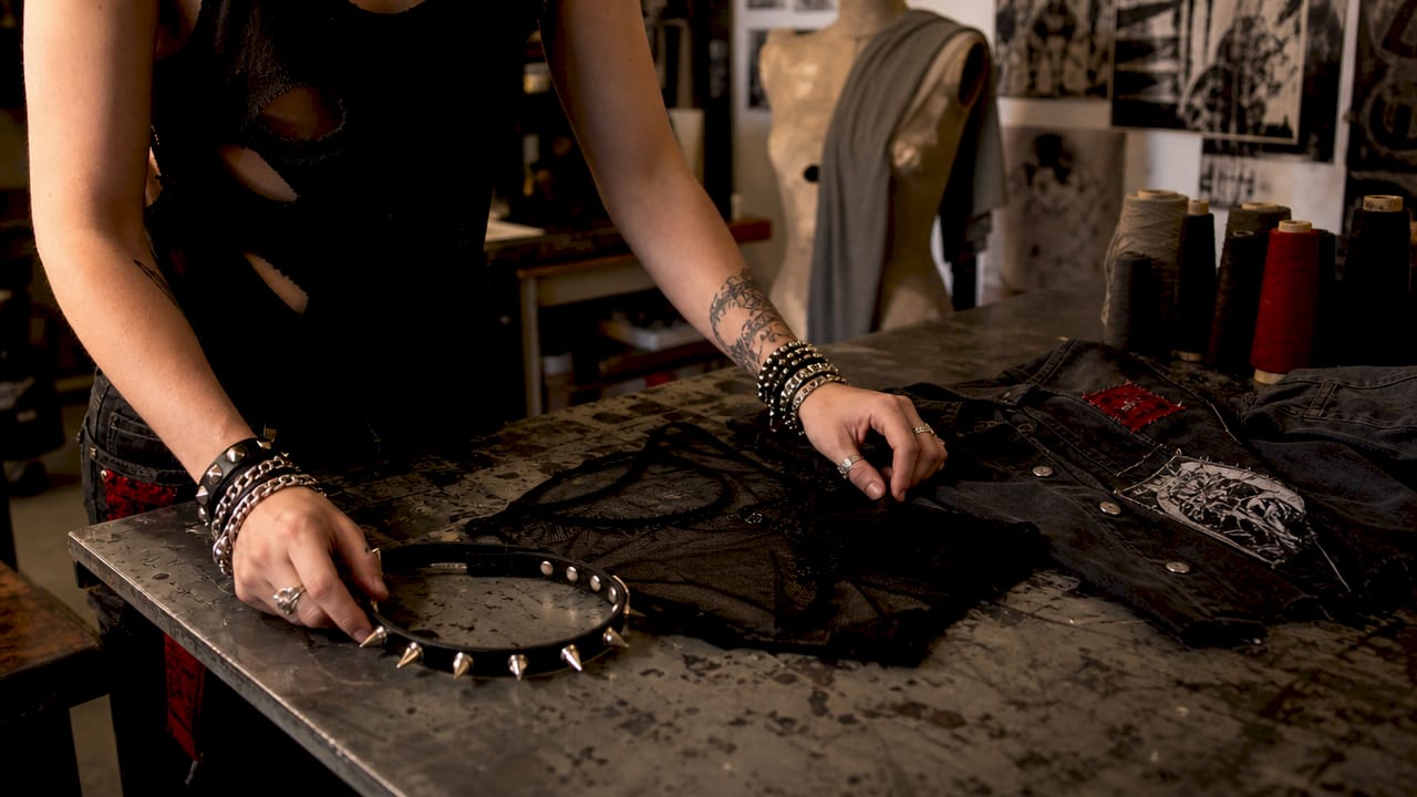 Stylist hands arranging dark alternative fashion pieces