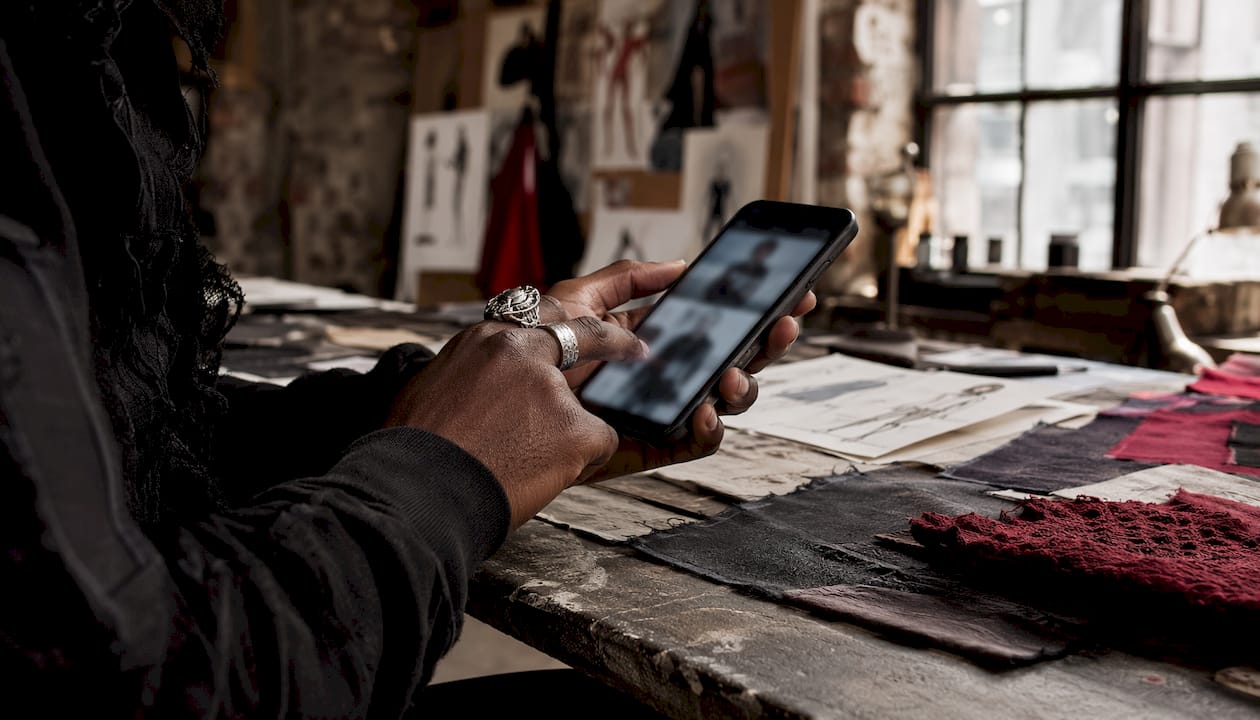 Hands tapping phone during fashion drop launch
