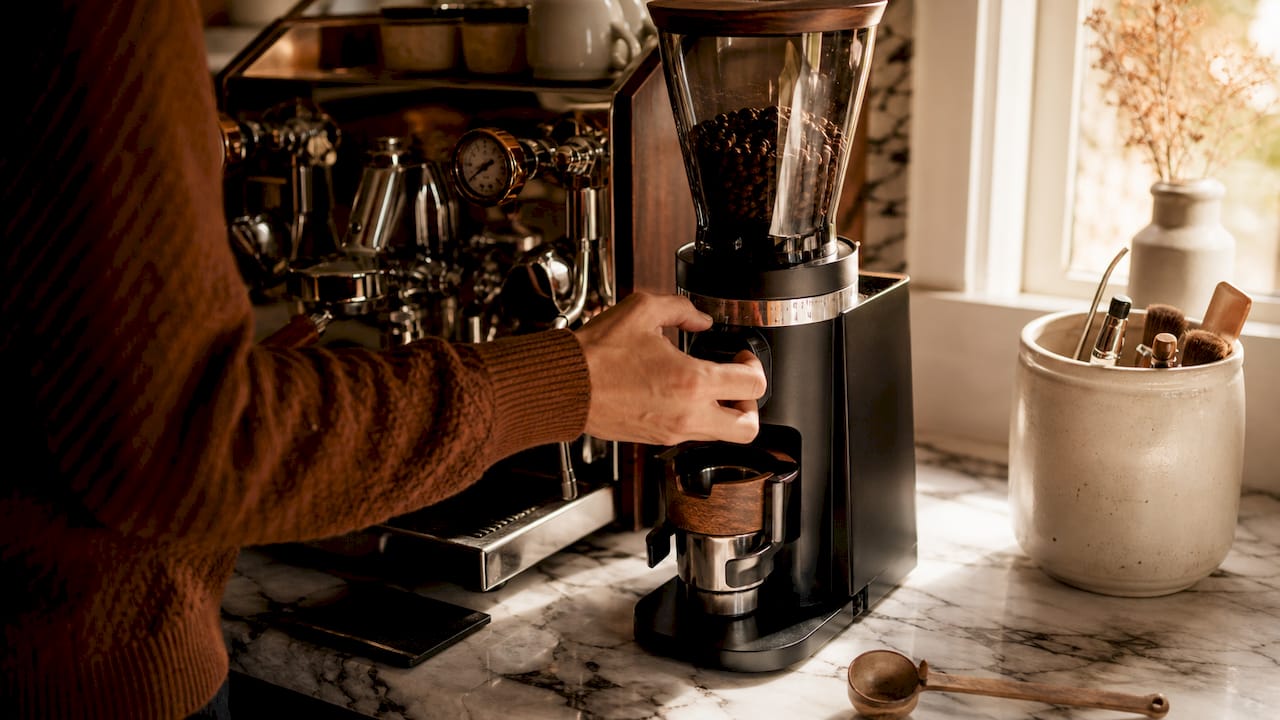 Hand adjusting home espresso grinder settings