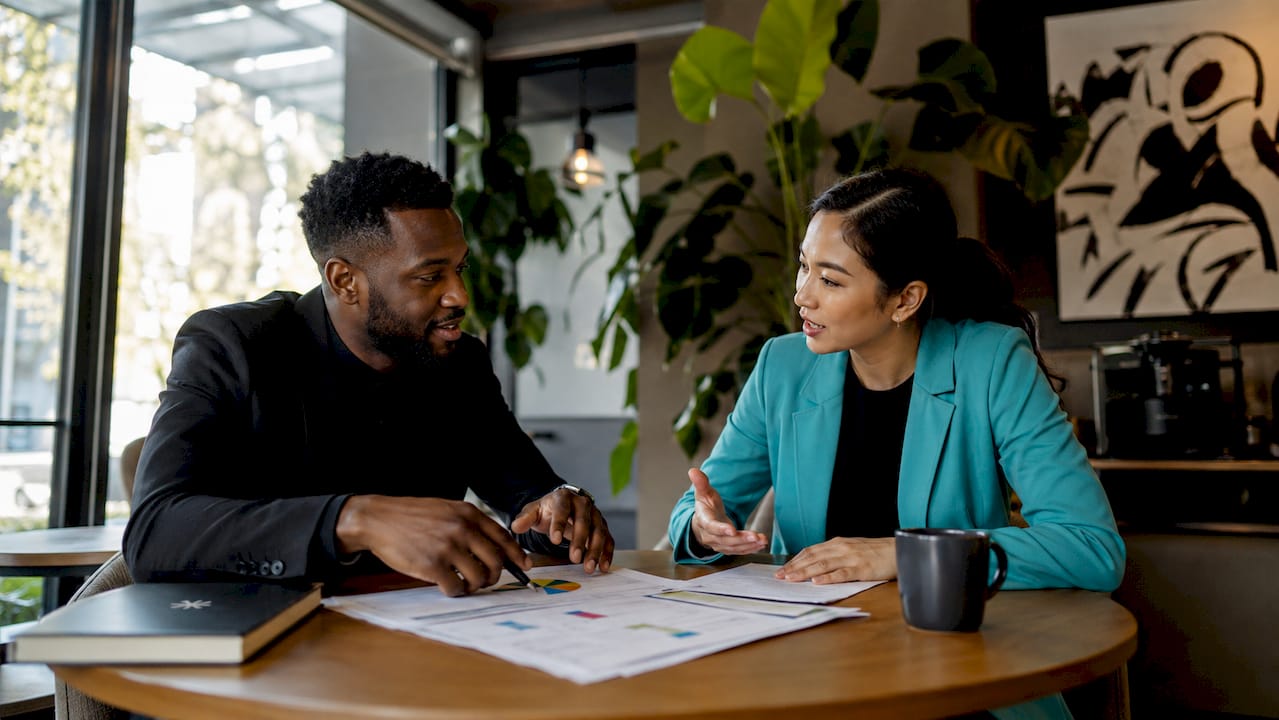 Overhead view of two professionals discussing career assessment documents