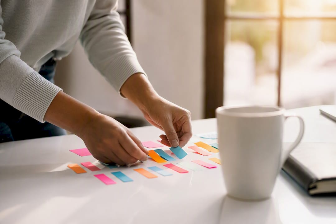 Hands placing colored priority tags on desk