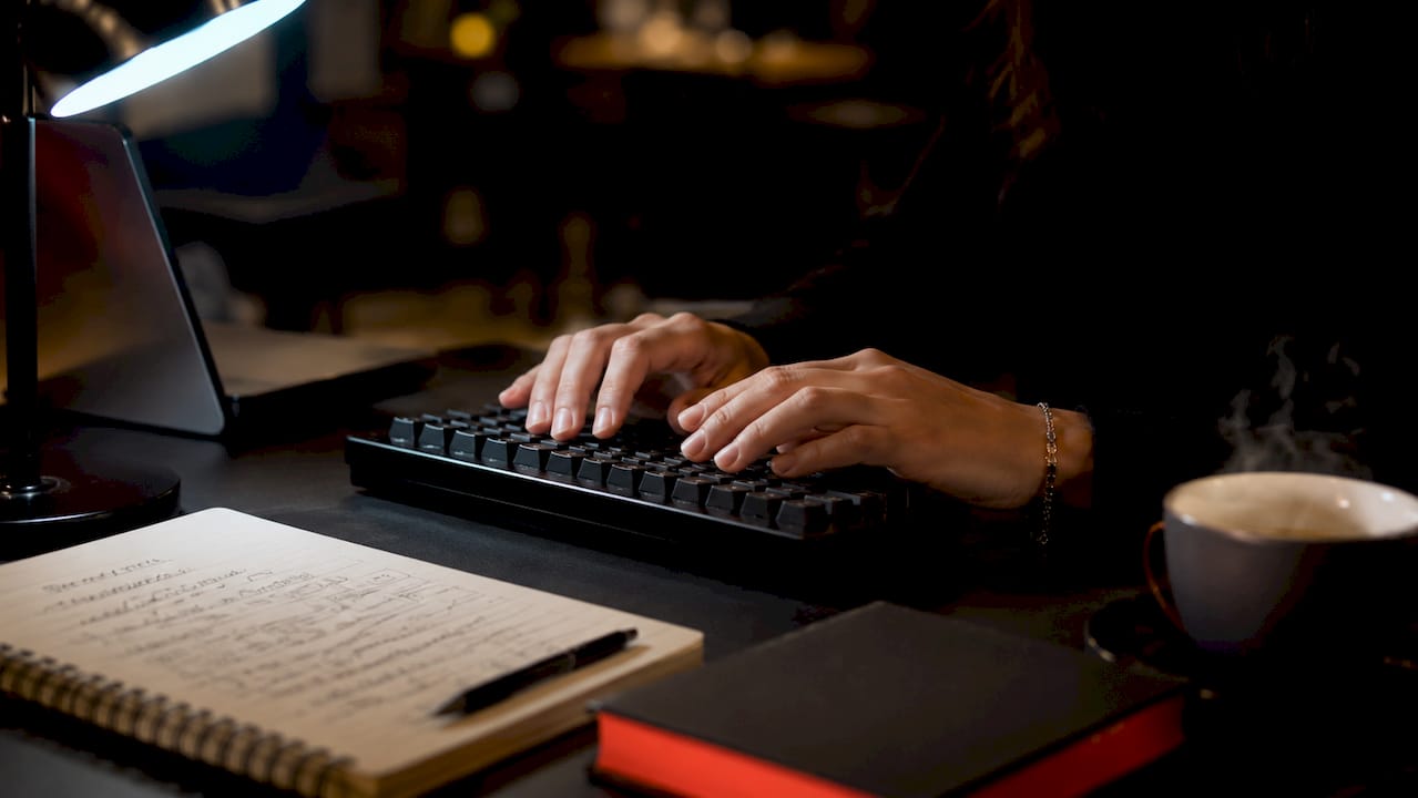 Ruolo del copywriting aziendale: guida 2026 2 Mani che digitano sulla tastiera con appunti di marketing sparsi accanto