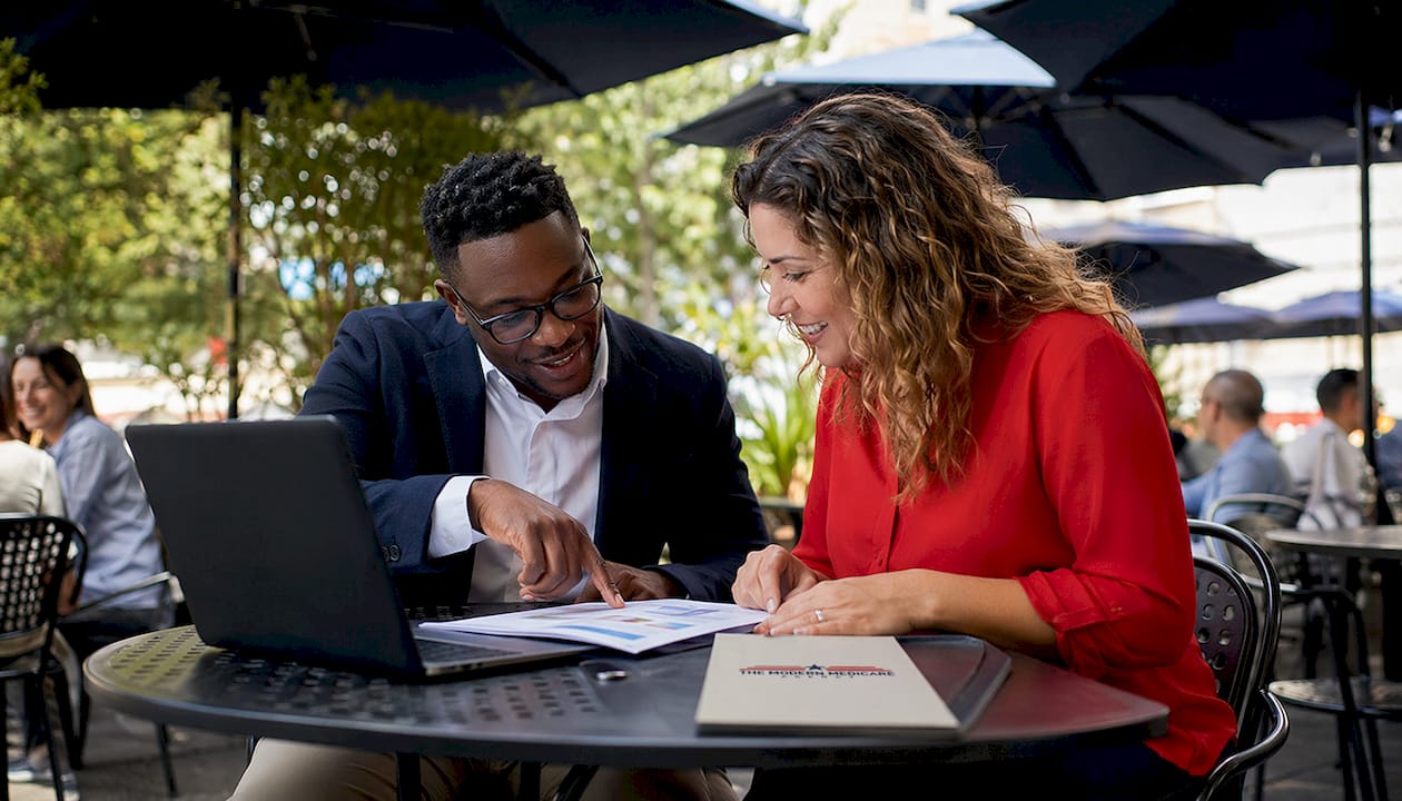 Coworkers discussing employer health benefits documents