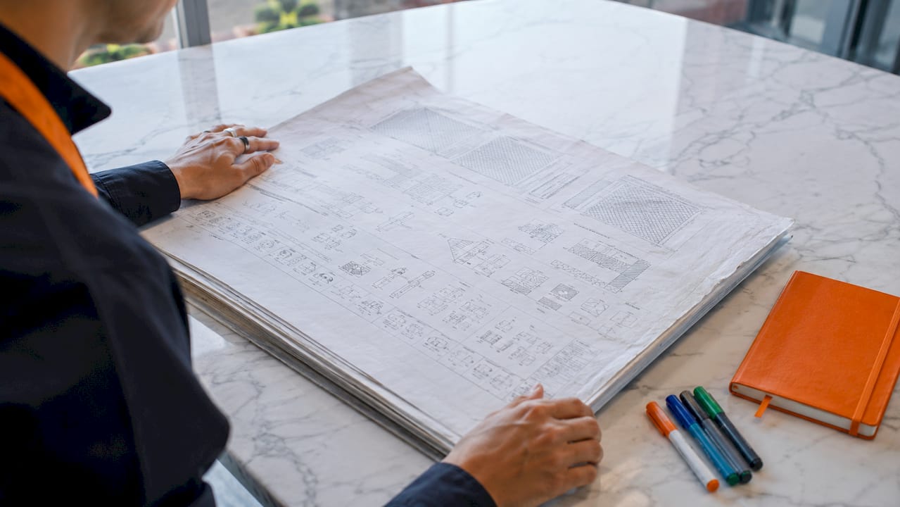 Hands reviewing blueprint cover sheet legend closely