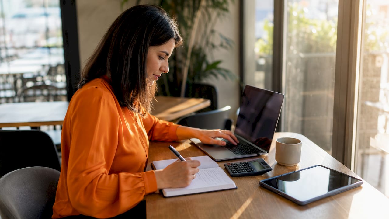 Project manager adjusting bids on keyboard with notes nearby
