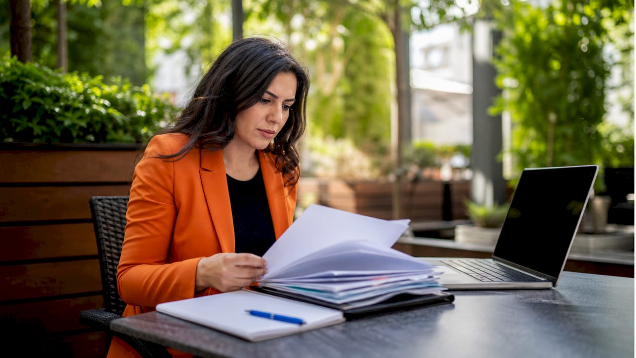 Hands reviewing subcontractor prequalification documents