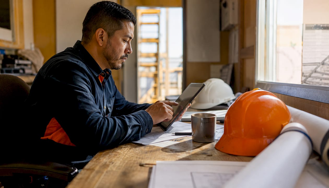 Hands reviewing estimate-linked cost forecast on tablet