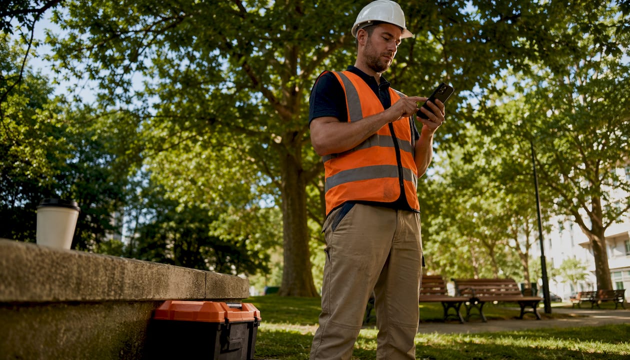 Subcontractor clocking in using mobile timesheet outdoors