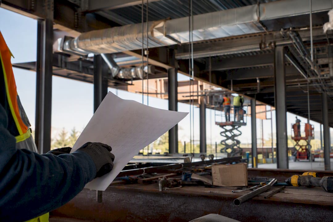 Gloved hand holding equipment schedule near HVAC installation