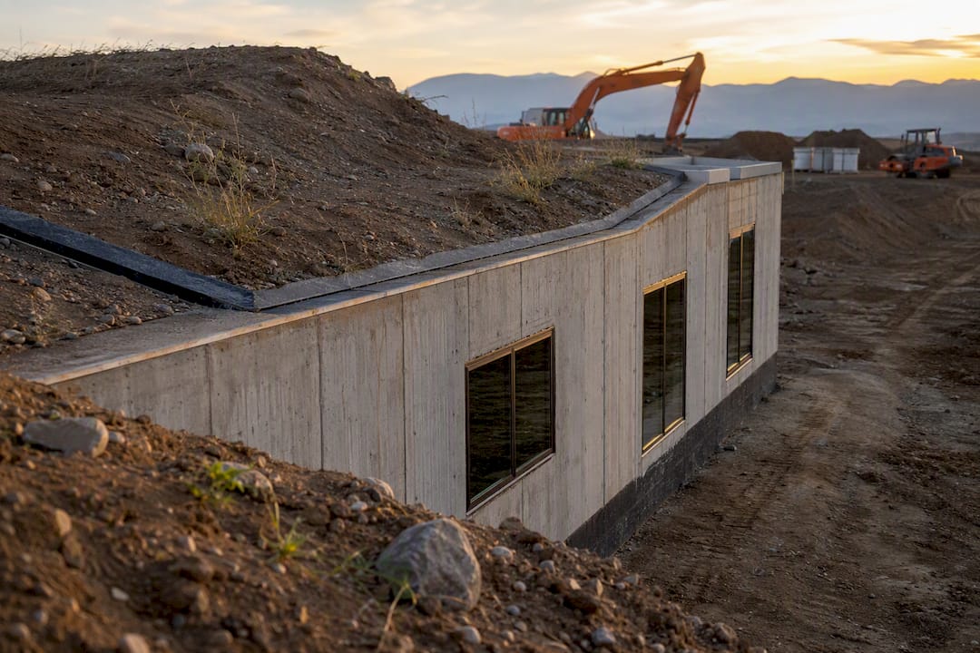 Partly buried house construction with earth berm