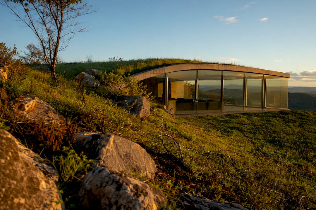 In-hill house with glass facade and green roof