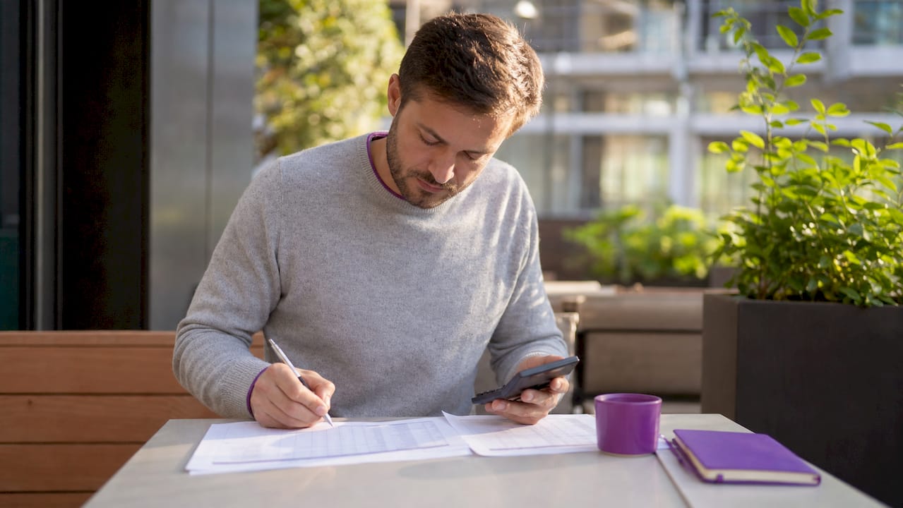 Agent calculating desk fees with calculator and documents