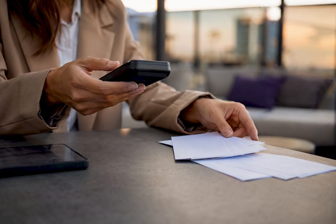 Hands handling payment terminal and commission slips