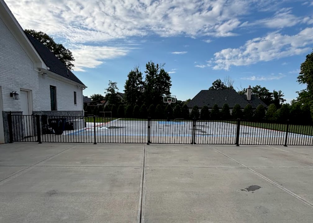 Hands comparing vinyl and aluminum pool fencing samples