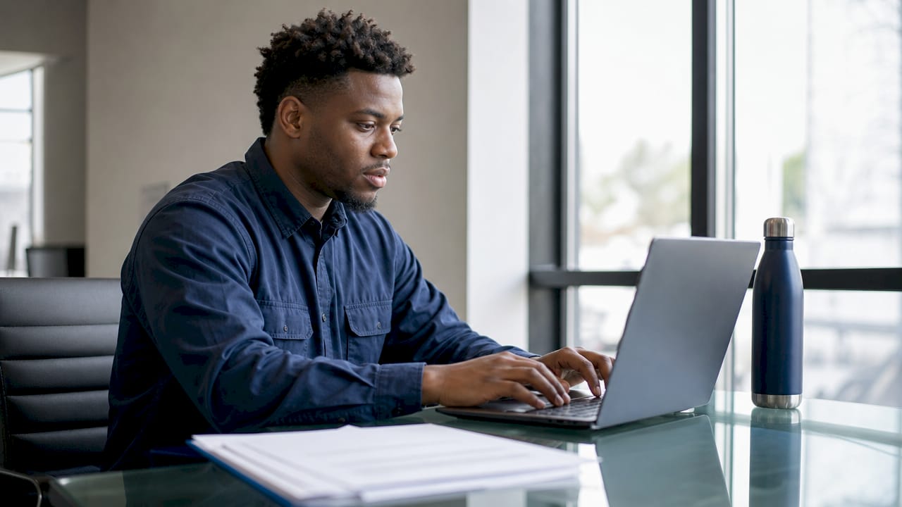 Electrician verifying license on laptop at desk