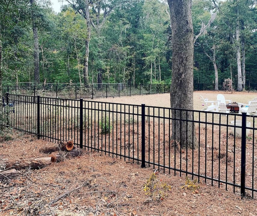 Hands cleaning black aluminum fence vs worn wood