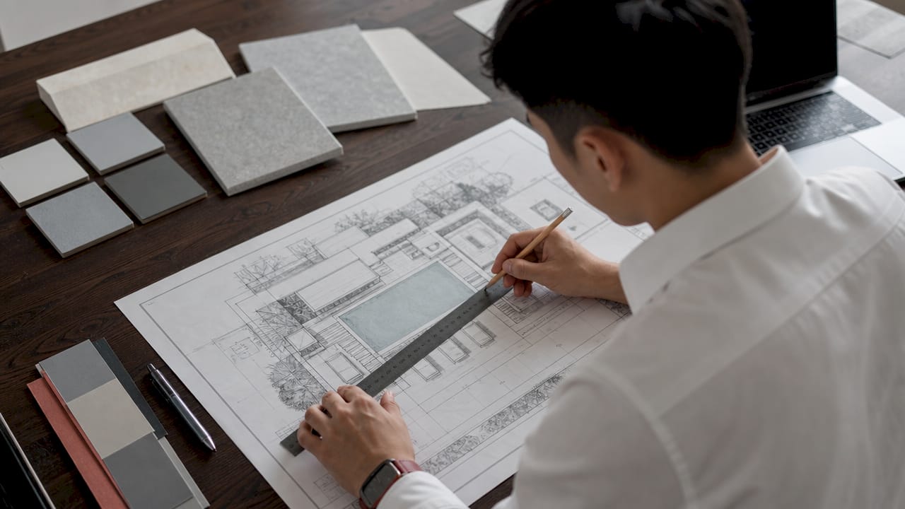 Hands adjusting blueprint of Lowcountry Modern pool