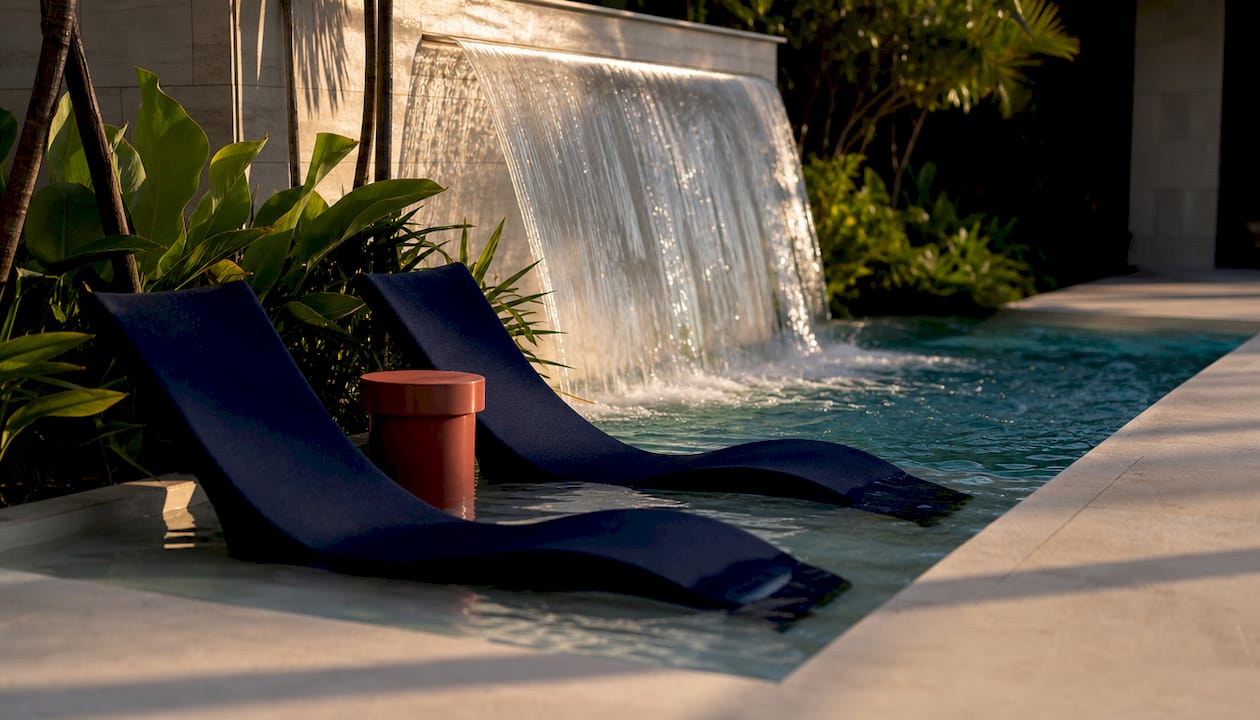Sheer descent water feature flowing into pool
