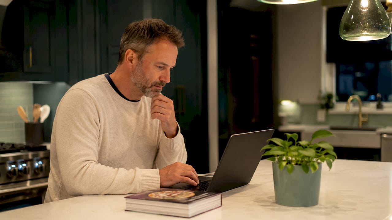 Man researching mattress sales at desk